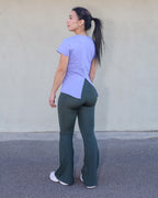 Vista trasera 3/4: Camiseta Lirio manga corta con apertura en espalda y Legging Peonia acampanado verde. Vima Studio