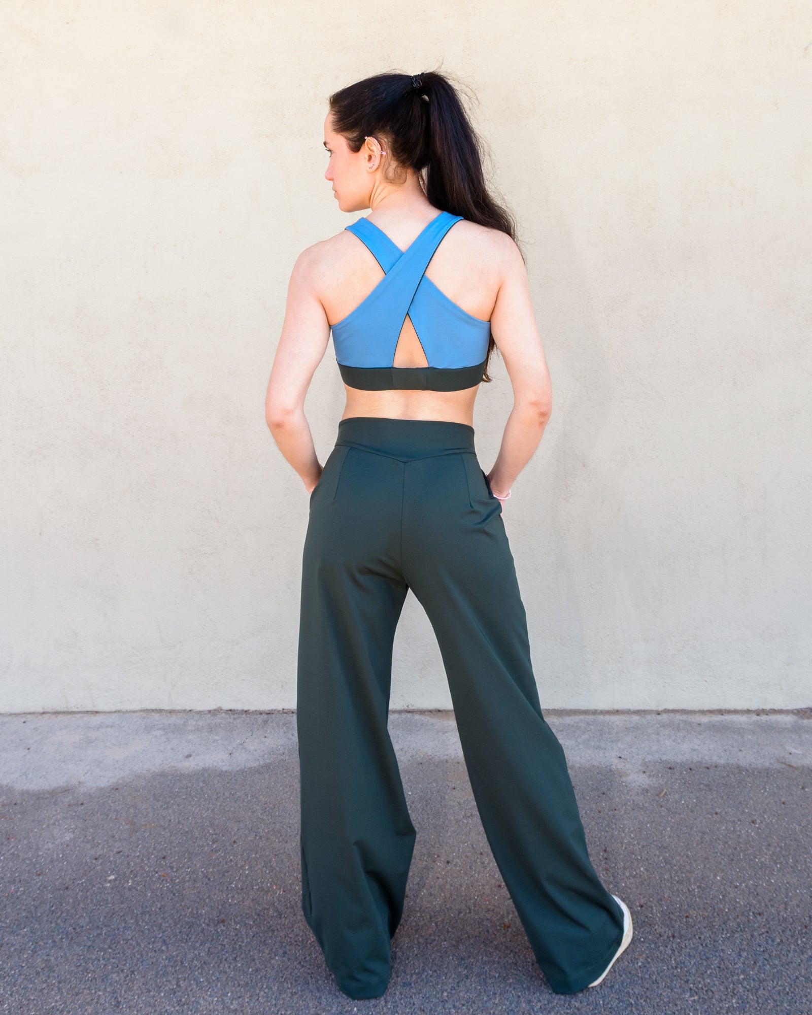 Espalda del look formado por el  top reversible "Girasol" con espalda cruzada y el pantalon Azalea con pinzas y talle alto en verde de Vima Studio
