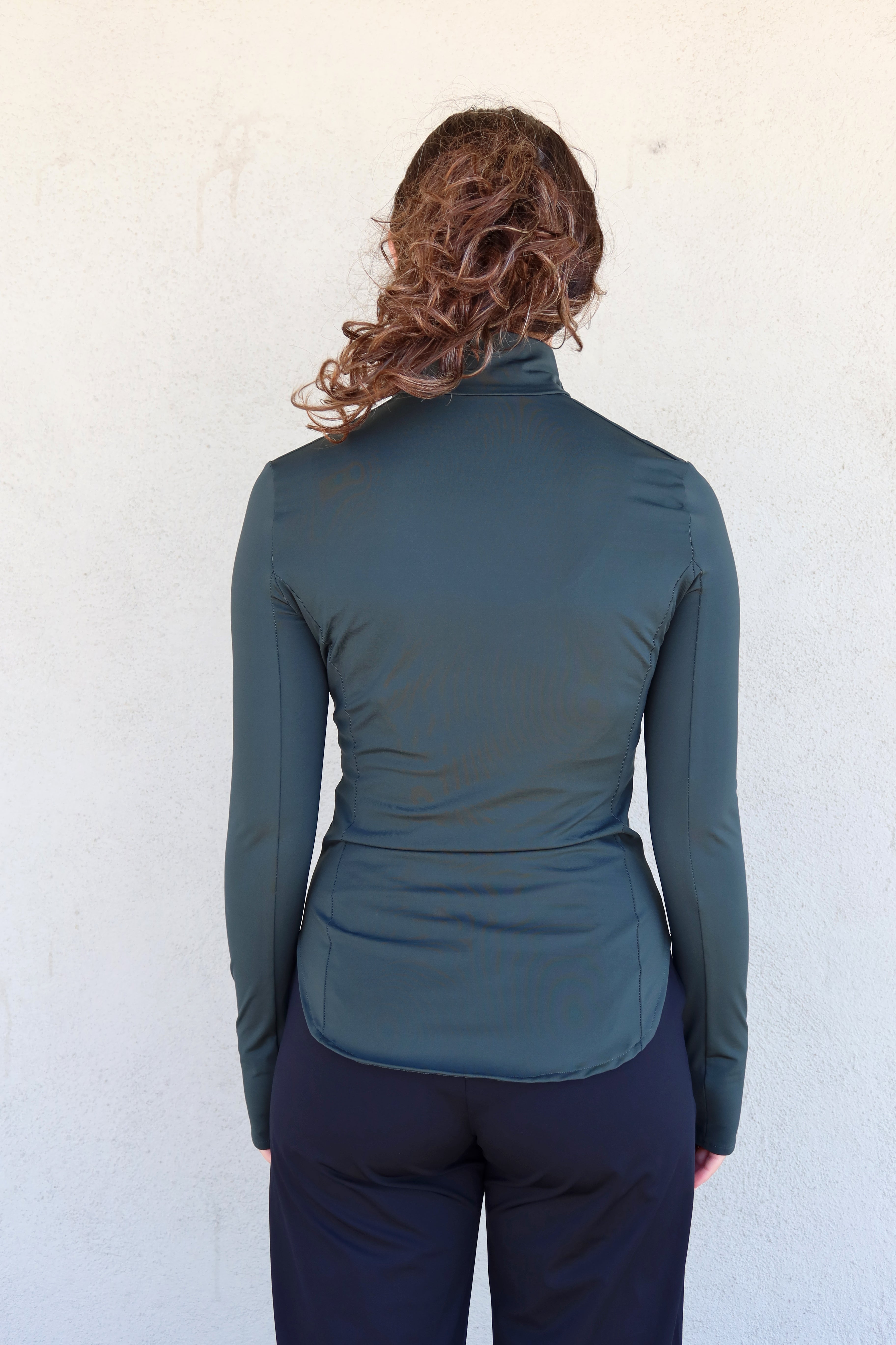 Espalda de la sudadera ajustada Magnolia en verde. Tiene cuello alto, mangas largas y costadillos. El bajo de la espalda es redondeado y más largo que en el delantero.