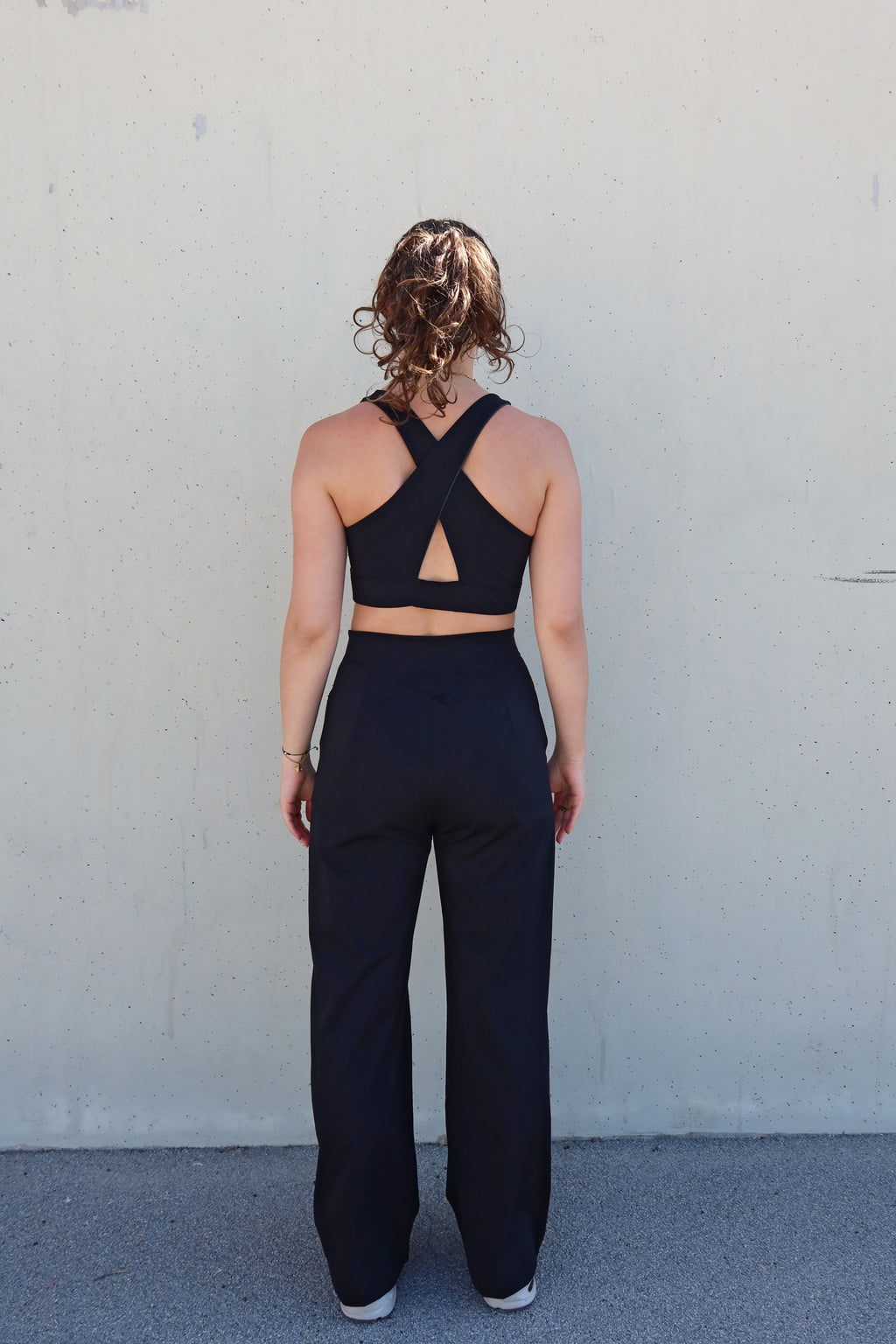 Look deportivo vima Studio: Sujetador reversible "Girasol" con espalda cruzada y pantalón suelto Azalea en negro.
